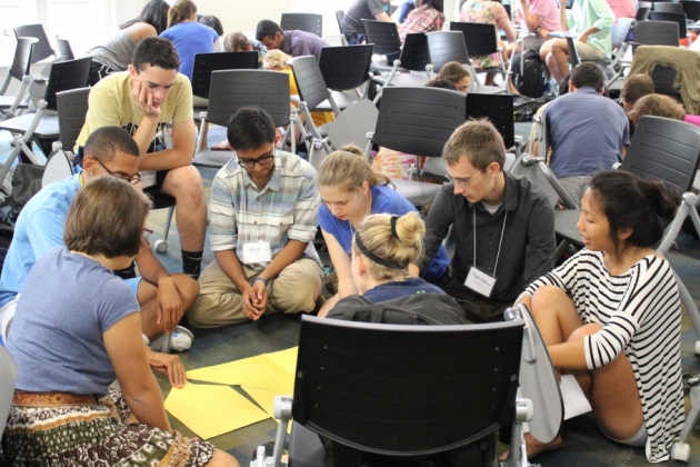 Group of students sitting on the floor working in teams.