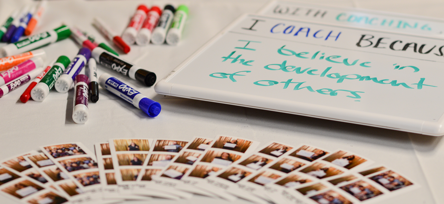 Dry markers, photos and a small whiteboard that reads "I believe in the development of others.”