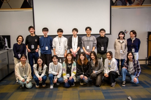 A cohort of students from the Institute of Science Tokyo pose for a group photo in a classroom, standing and kneeling in two rows in front of a projection screen.